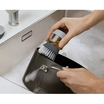 Mycí kartáč Joseph Joseph Palm Scrub, šedý, s integrovaným dávkovačem prostředku na nádobí